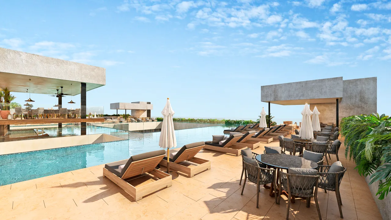 ceiba-at-25-playa-del-carmen-rooftop-infinity-pool.webp Rooftop infinity pool and bar at Ceiba at 25, overlooking a sports stadium in Playa del Carmen.